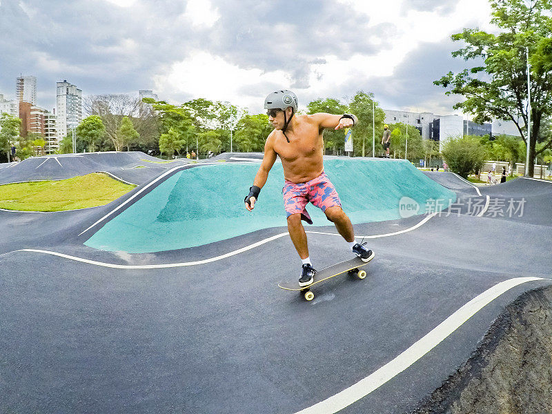 2021年12月10日，巴西圣保罗，一名成年男子在自行车公园(São Paulo, State São Paulo)的柏油路上骑着滑板